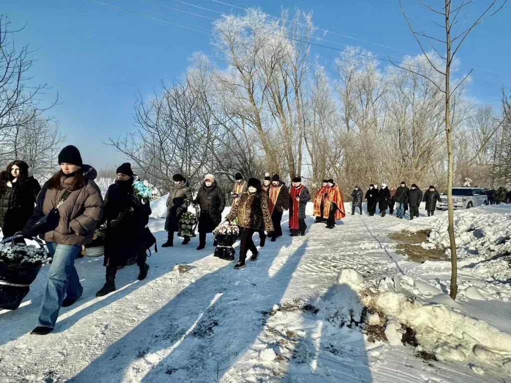 Похоронна процесія йде засніженою дорогою взимку
