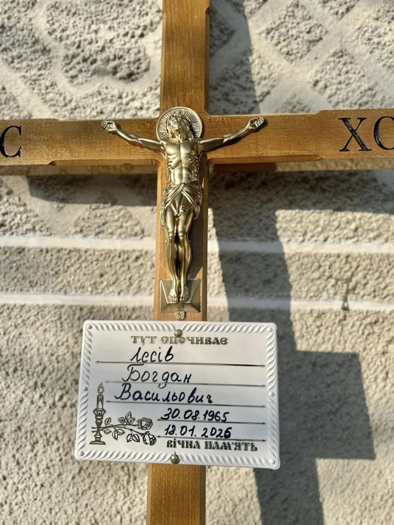 Дерев'яний хрест із табличкою на могилі