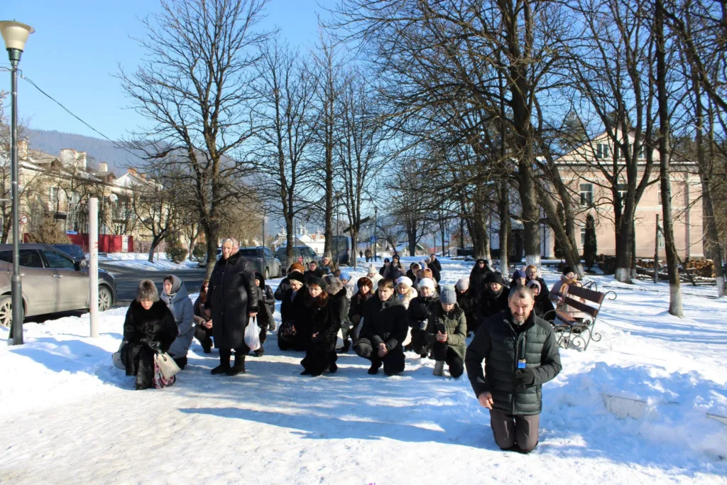 Люди стають на коліна на снігу взимку