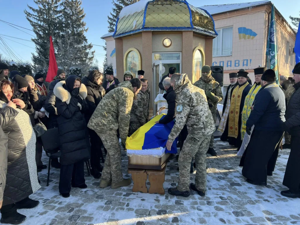 Похорон загиблого воїна з українським прапором