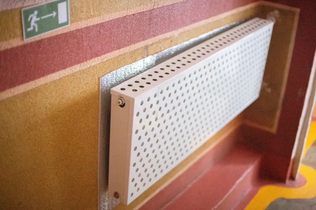 Настінний радіатор поруч із знаком виходу