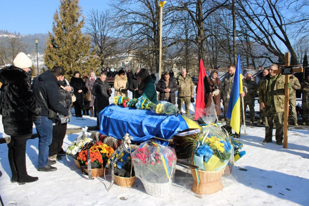 Похорон українського військового з прапорами та квітами