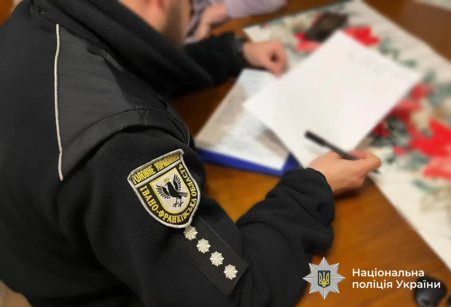 Поліцейський заповнює документи за столом