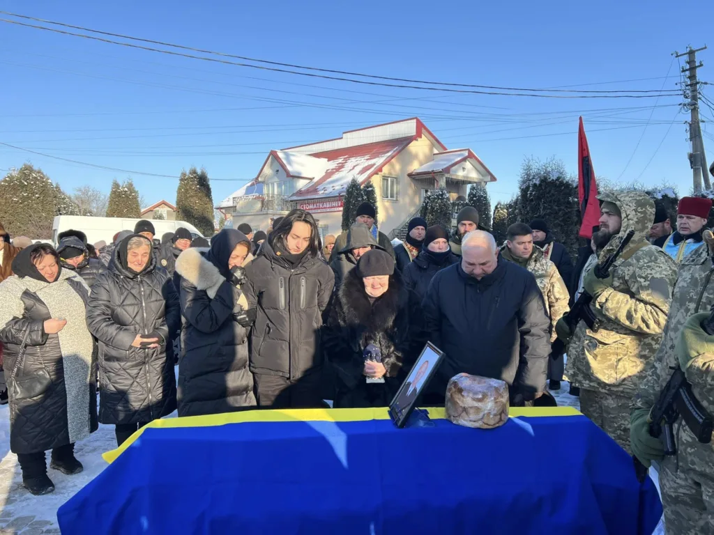 Люди прощаються із загиблим військовим під час церемонії