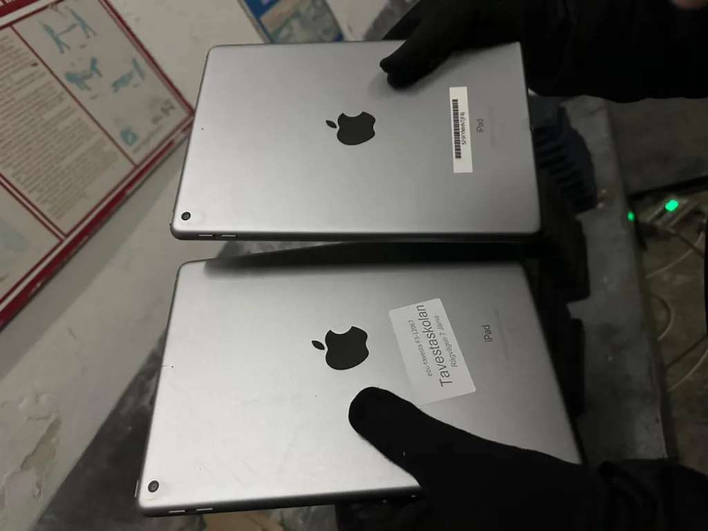 Два сріблясті планшети Apple iPad у рукавицях