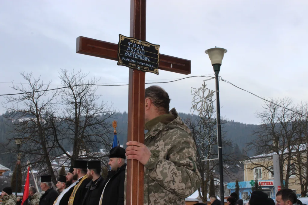 Військовий тримає хрест на церемонії прощання