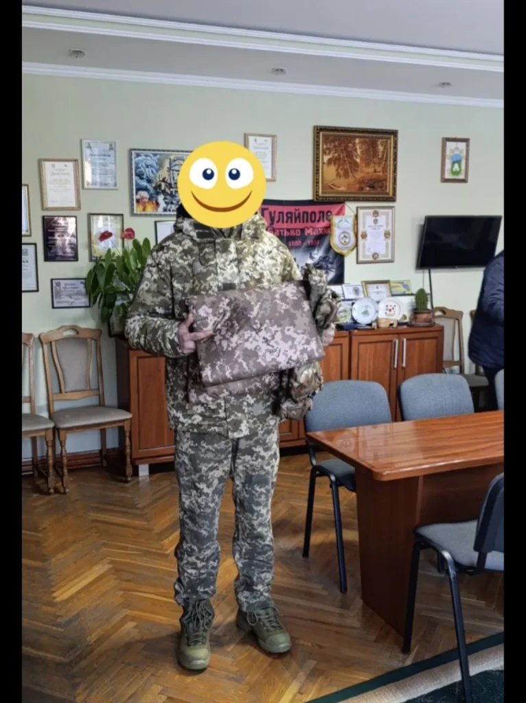 Військовий у камуфляжі тримає пакунок у кімнаті