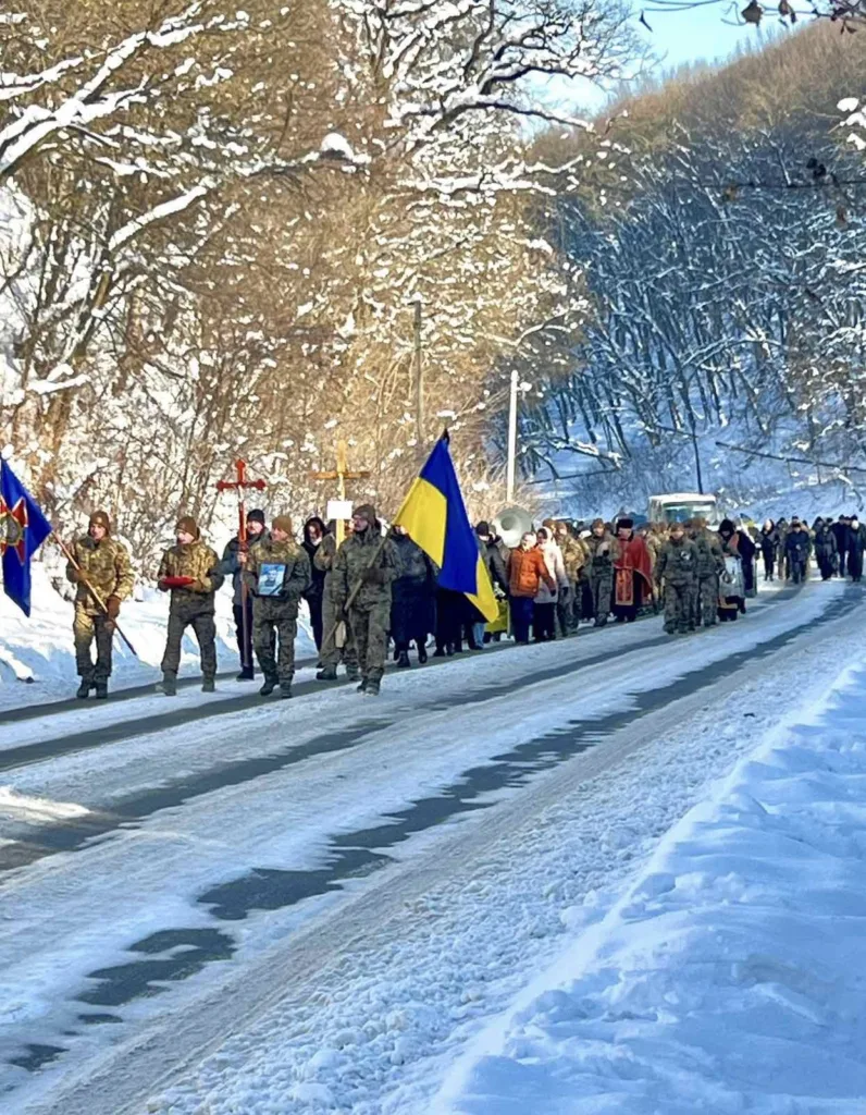 Військовий марш із українським прапором зимою