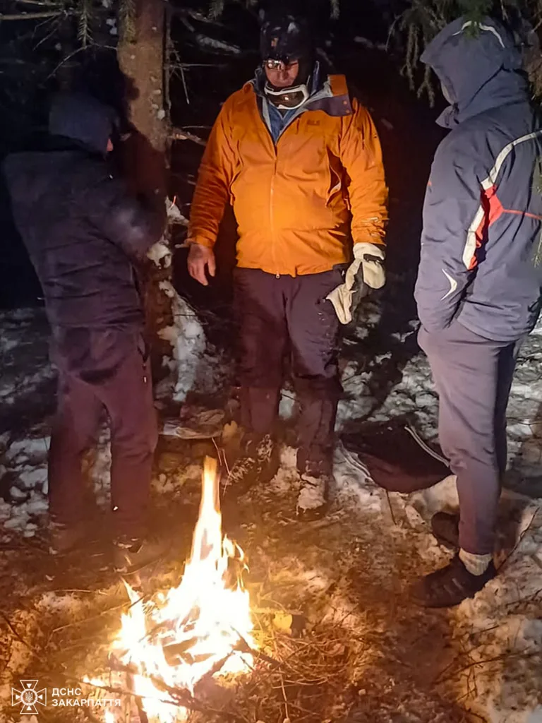 Рятувальники біля вогнища в зимовому лісі