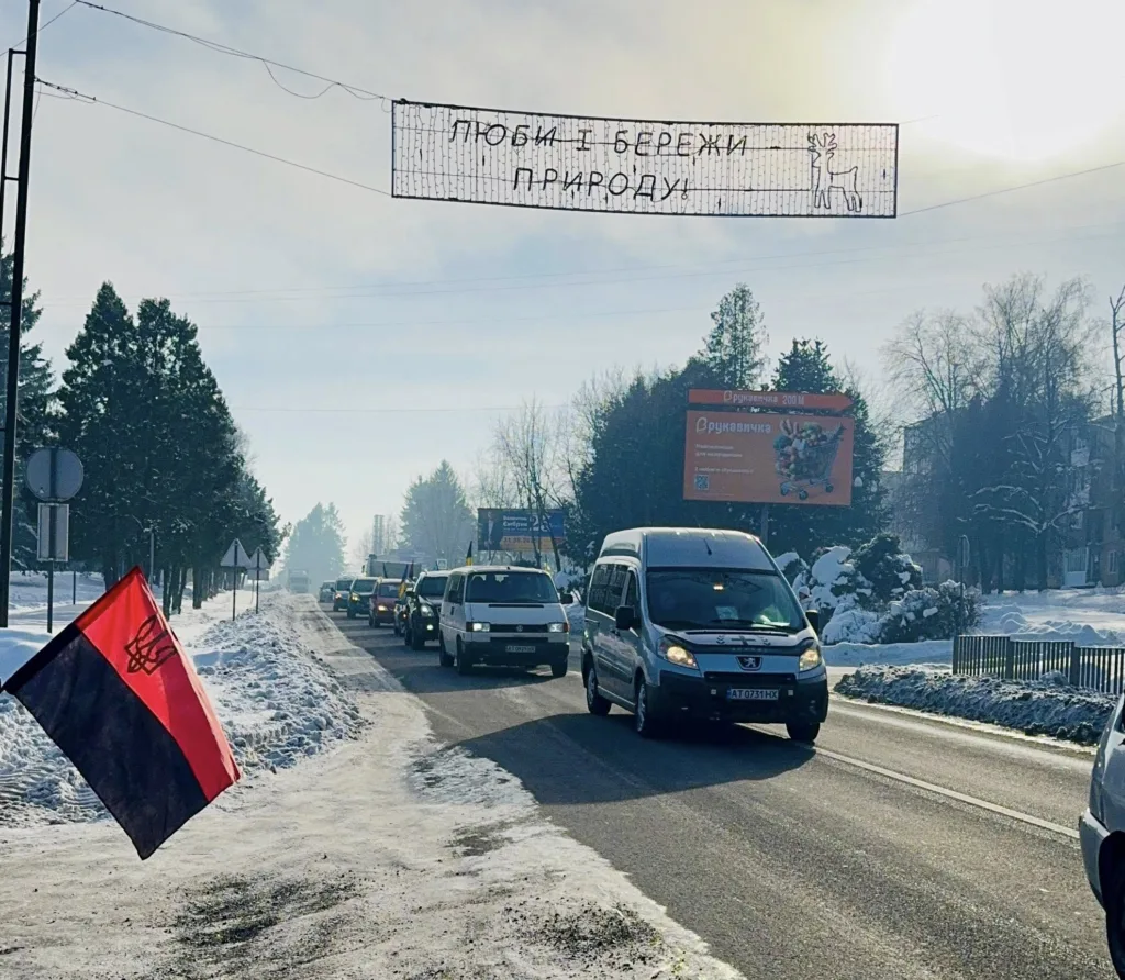 Автомобілі на зимовій дорозі з прапором України