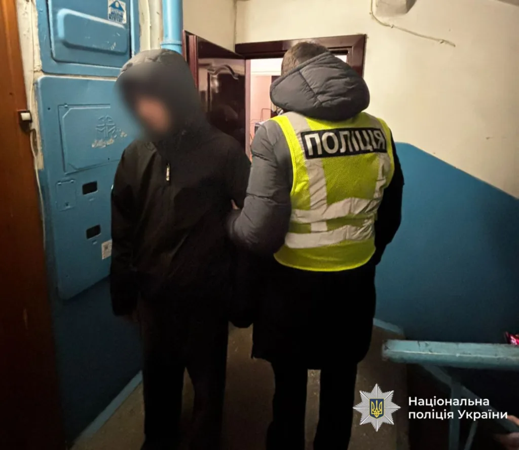 Поліцейський затримує підозрюваного у під'їзді будинку
