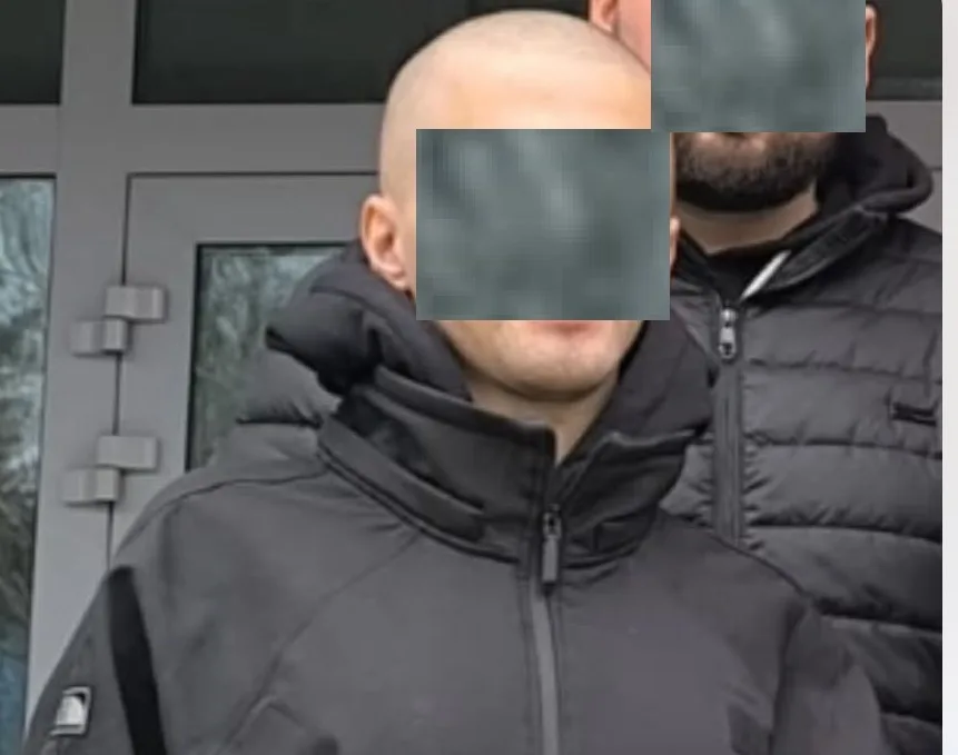 Двоє чоловіків у чорних куртках перед дверима