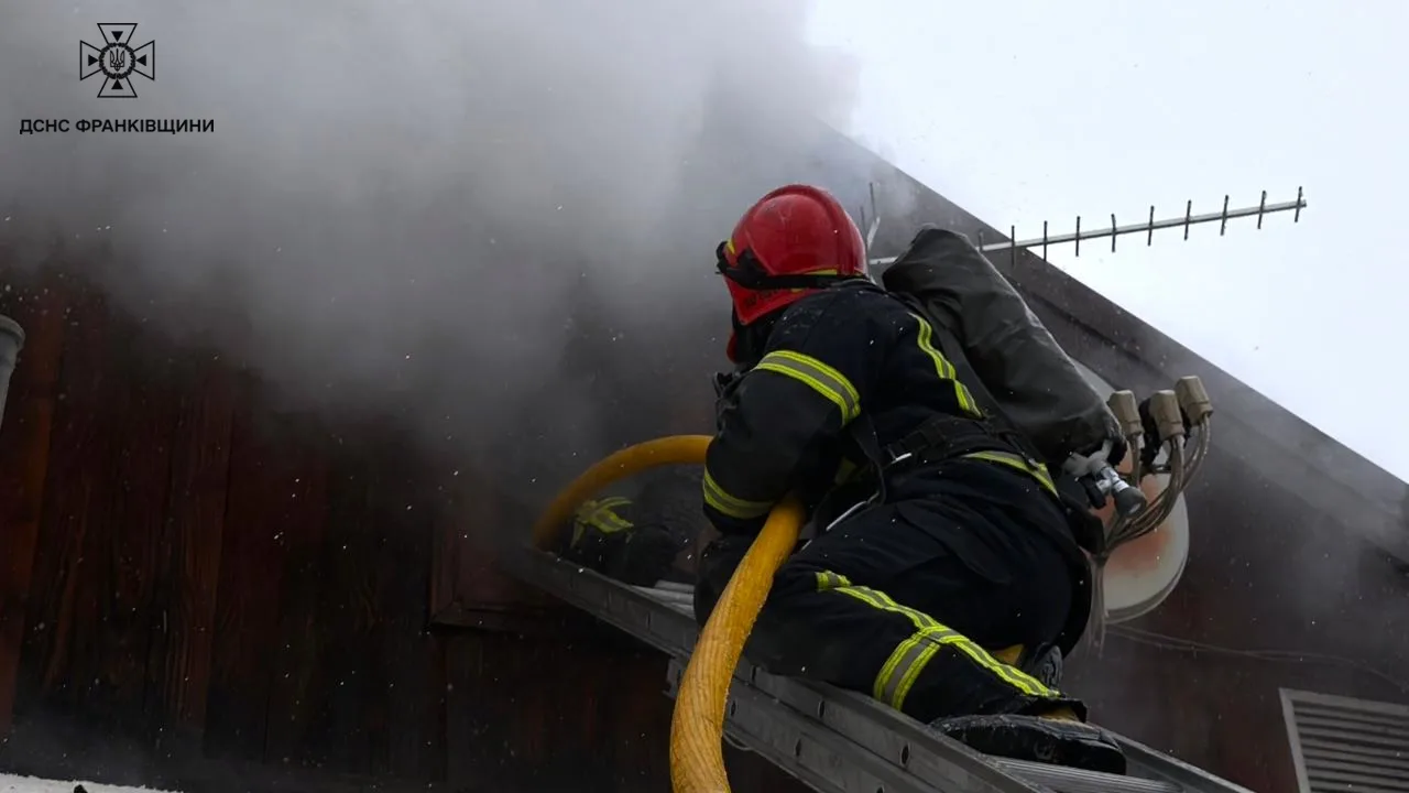 Пожежник гасить вогонь у будинку зі сходів