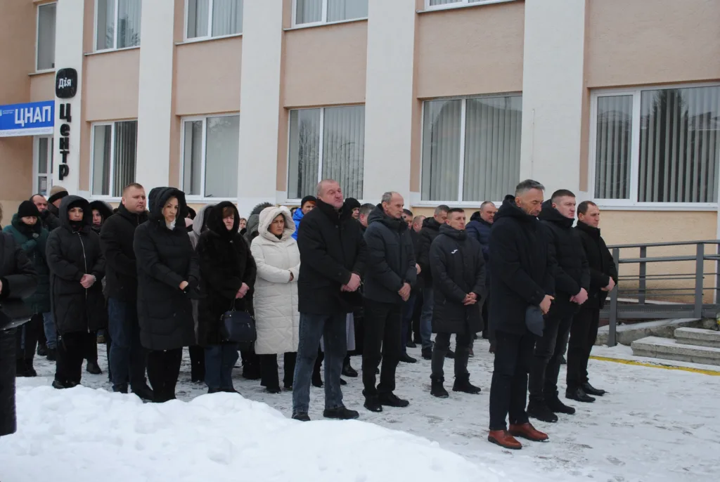 Люди стоять біля ЦНАП на вулиці взимку