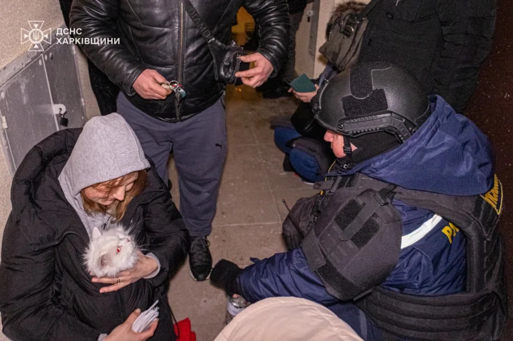 Рятувальник допомагає людям у підвалі Харкова