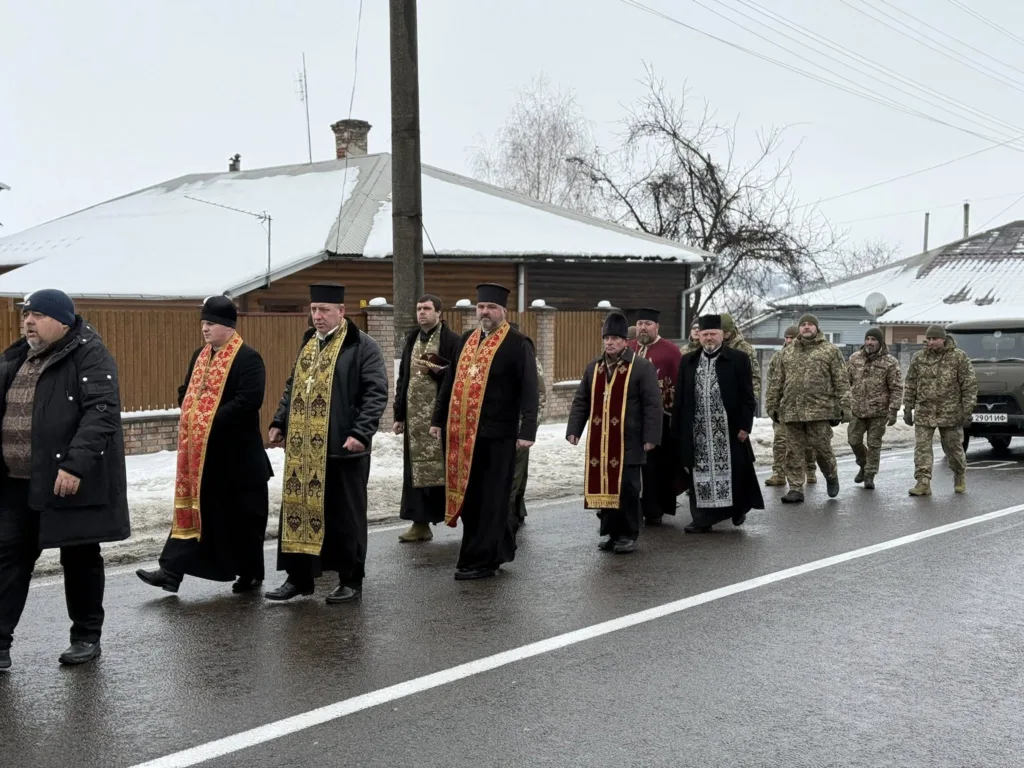 Священники та військові йдуть вулицею взимку