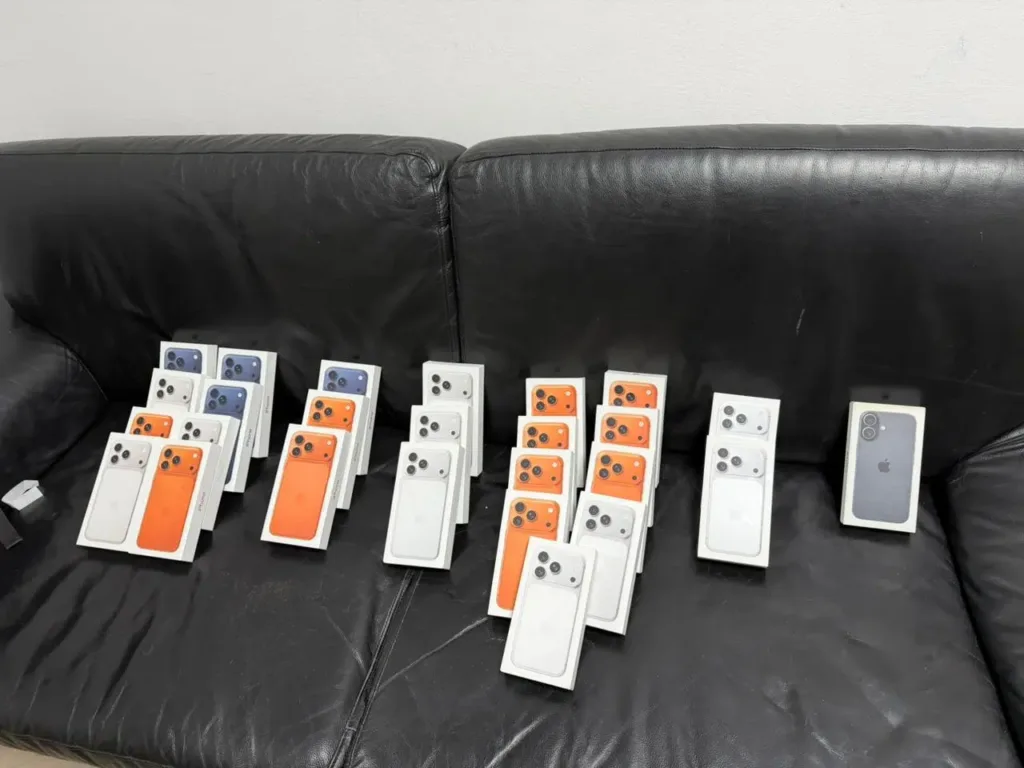 Кілька коробок нових iPhone на чорному дивані