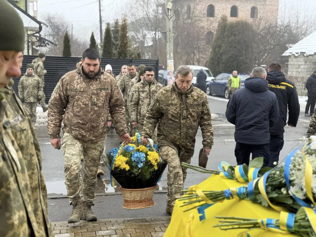 Військові несуть кошик квітів до жалобної церемонії