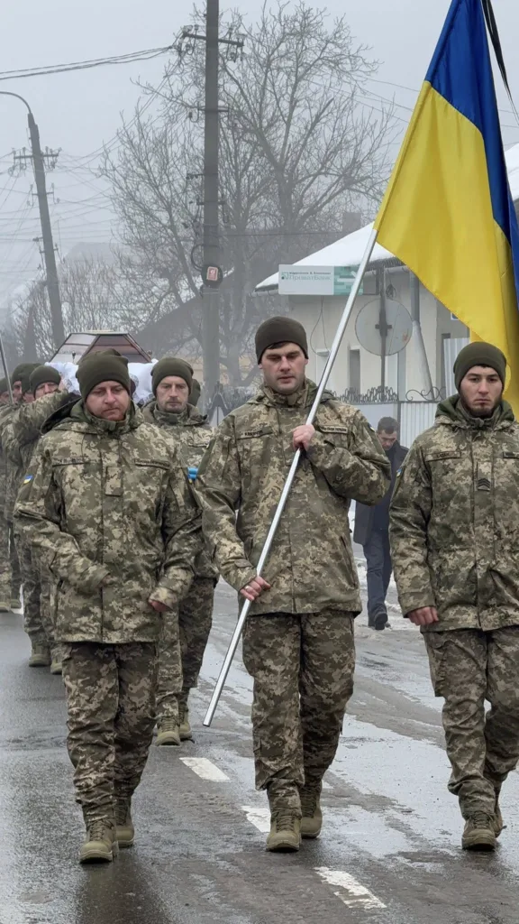 Українські військові несуть прапор під час церемонії