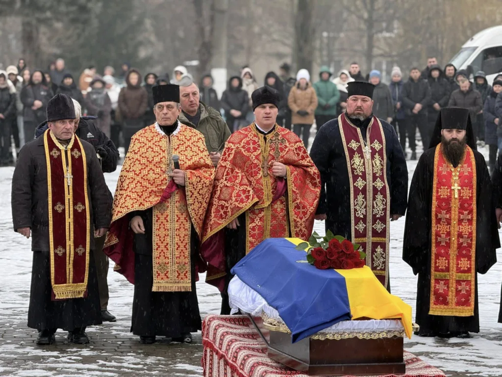 Священники проводжають героя з прапором України