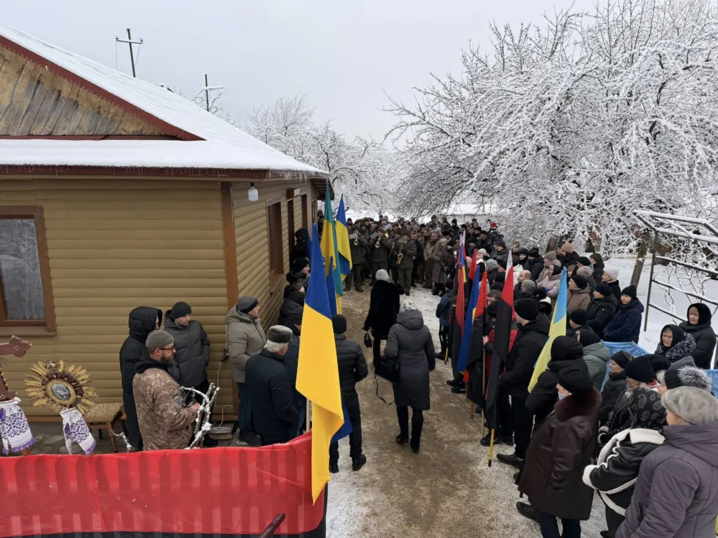 Зимова церемонія з людьми та українськими прапорами