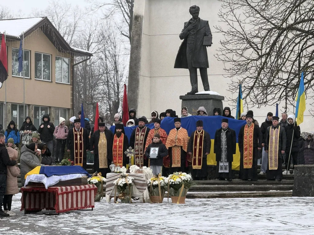 Похоронна церемонія біля пам'ятника взимку