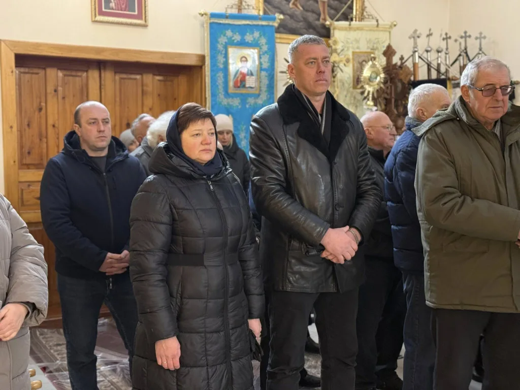 Люди стоять на церковній службі в храмі