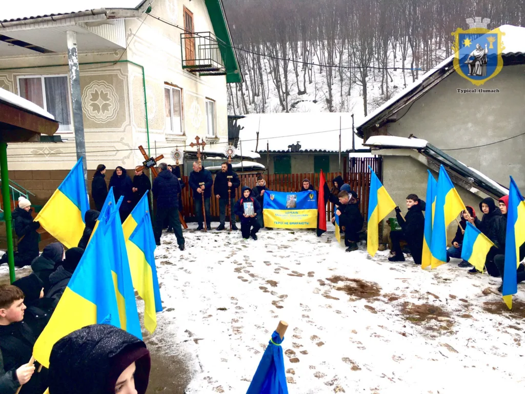 Люди з українськими прапорами на зимовій церемонії