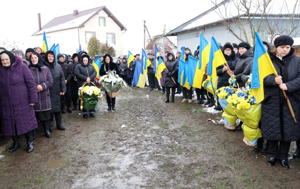 Люди з українськими прапорами на вуличному зібранні