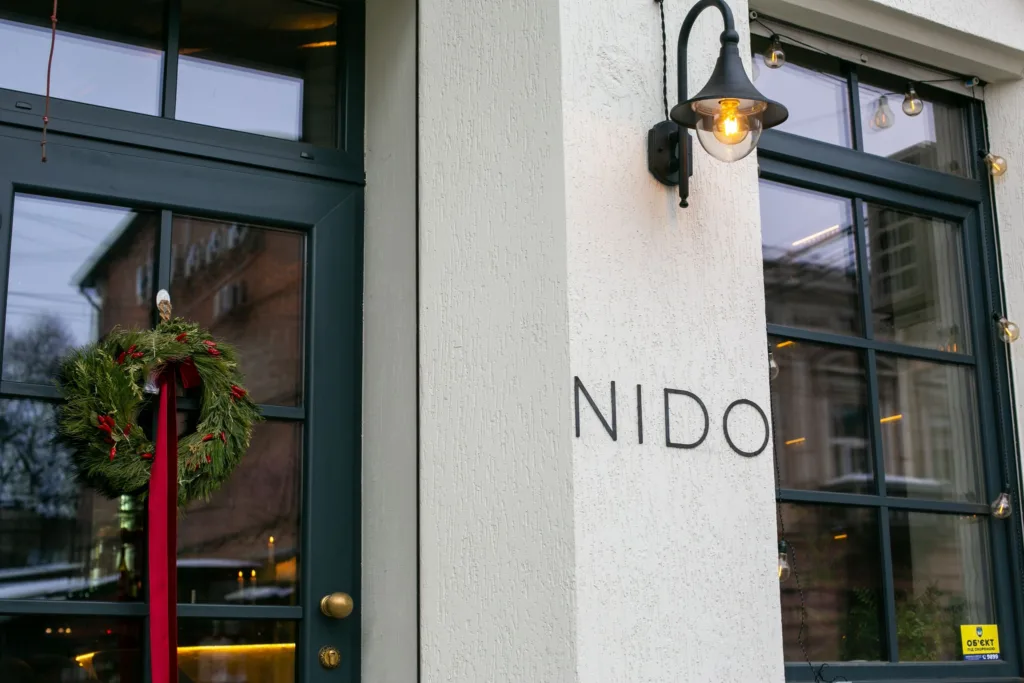 Вхід до ресторану NIDO з різдвяним вінком