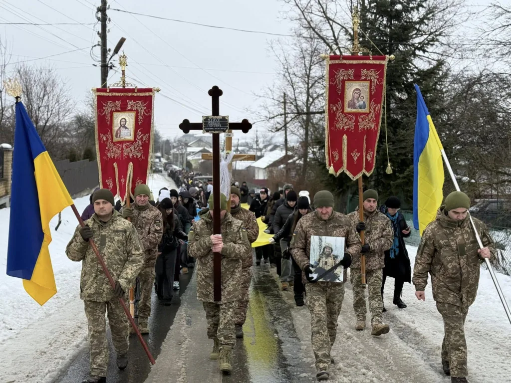 Військові з прапорами на похоронній процесії в Україні