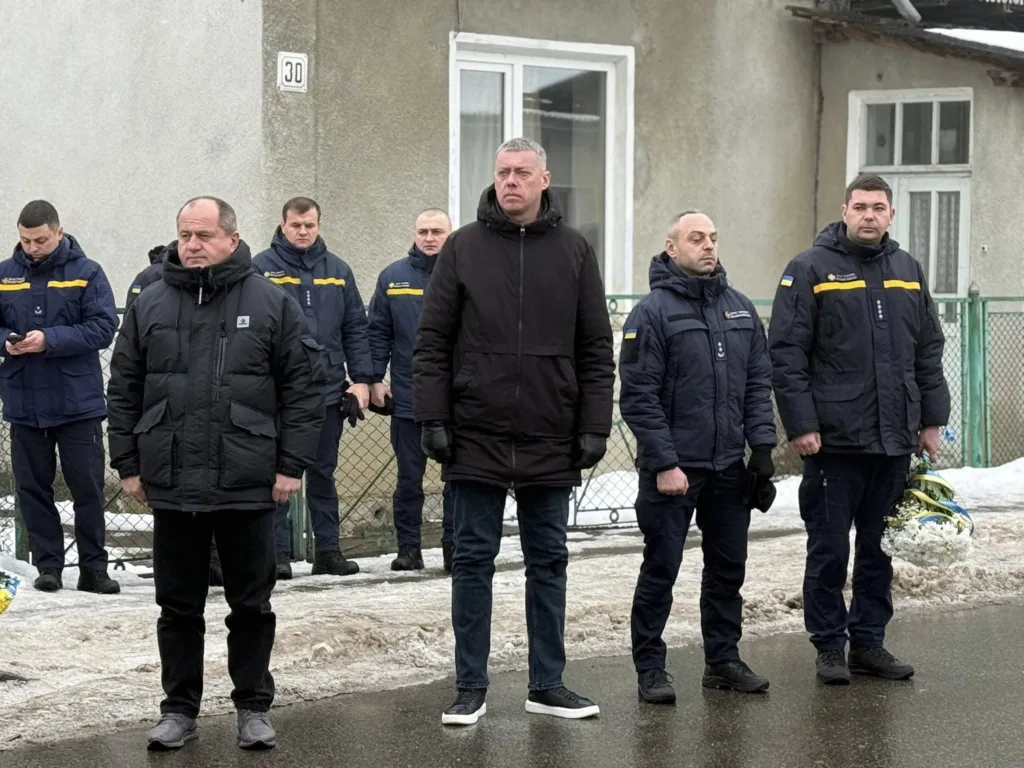 Рятувальники стоять на вулиці біля будинку