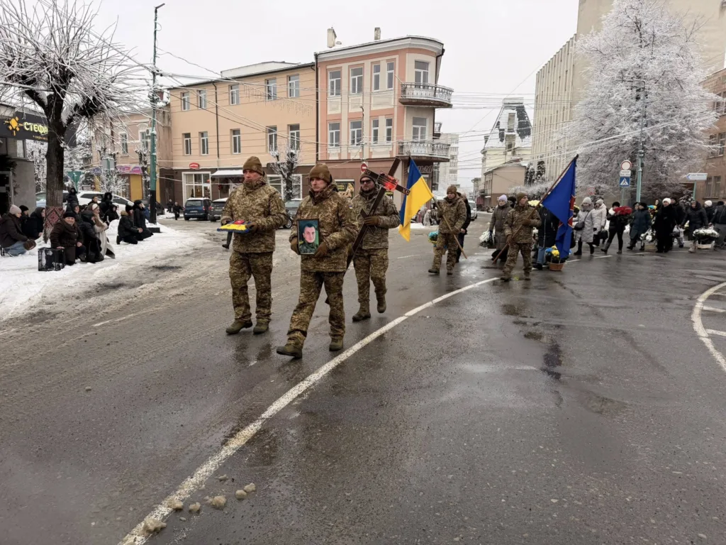 Військові несуть прапори під час похоронної процесії