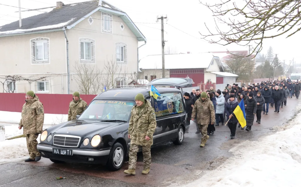 Похоронна процесія військових з українським прапором