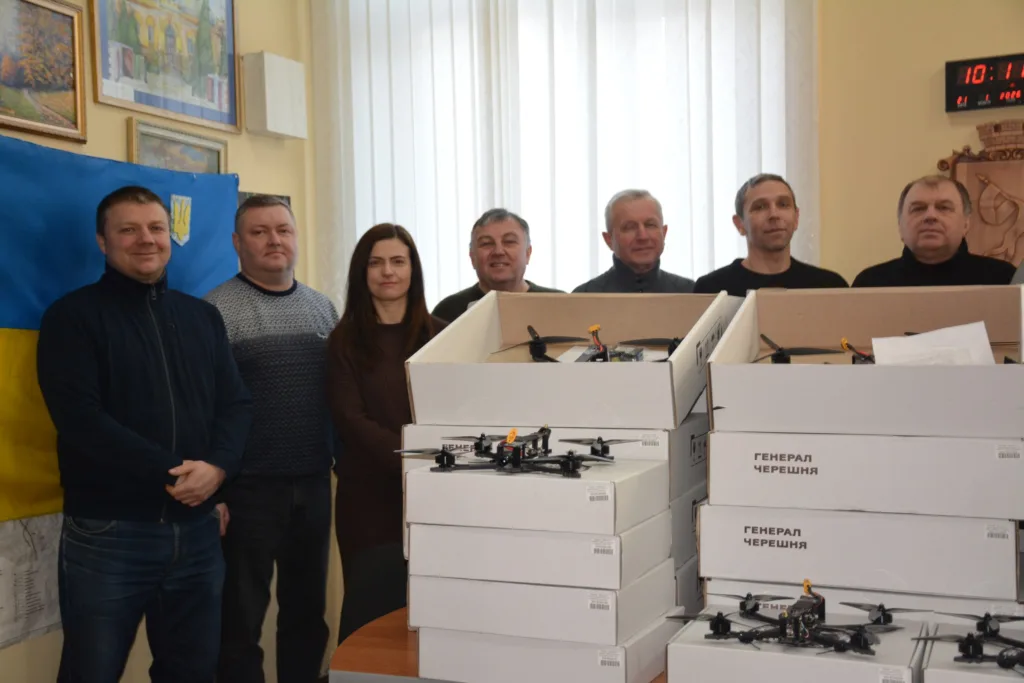 Група людей з коробками безпілотників у приміщенні