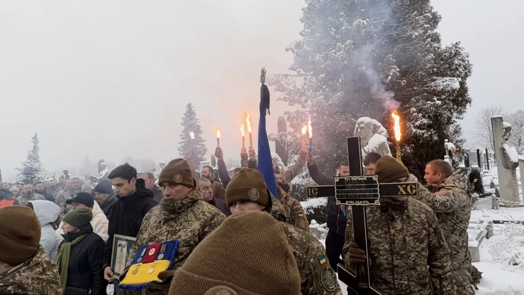 Військові на похороні взимку з факелами