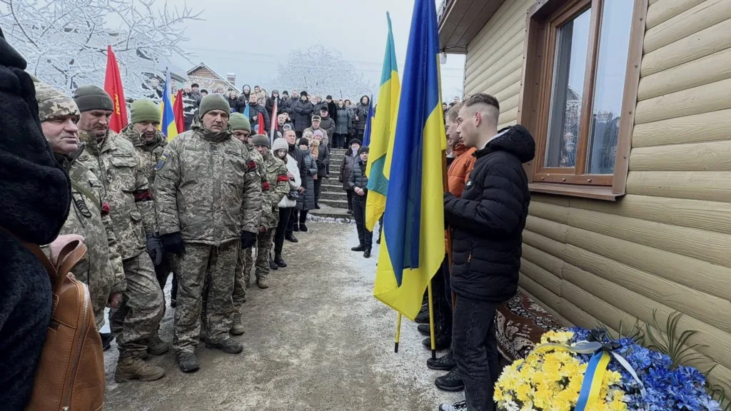 Військові та громадяни на церемонії з прапорами України