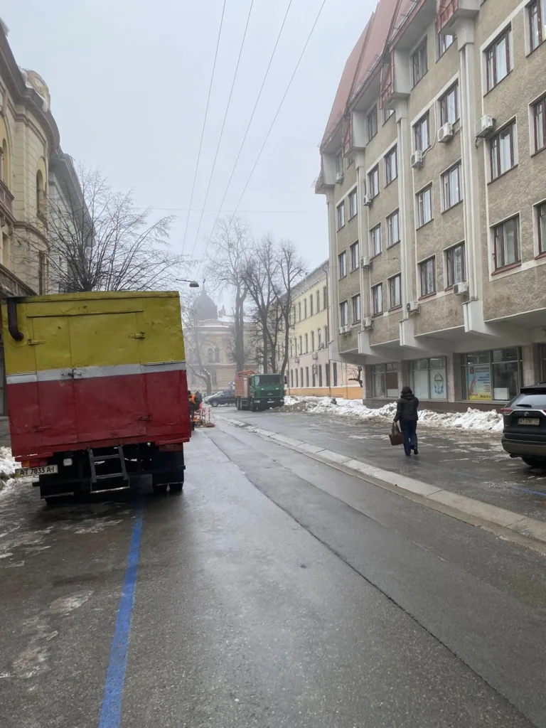 Зимова вулиця міста з припаркованими вантажівками