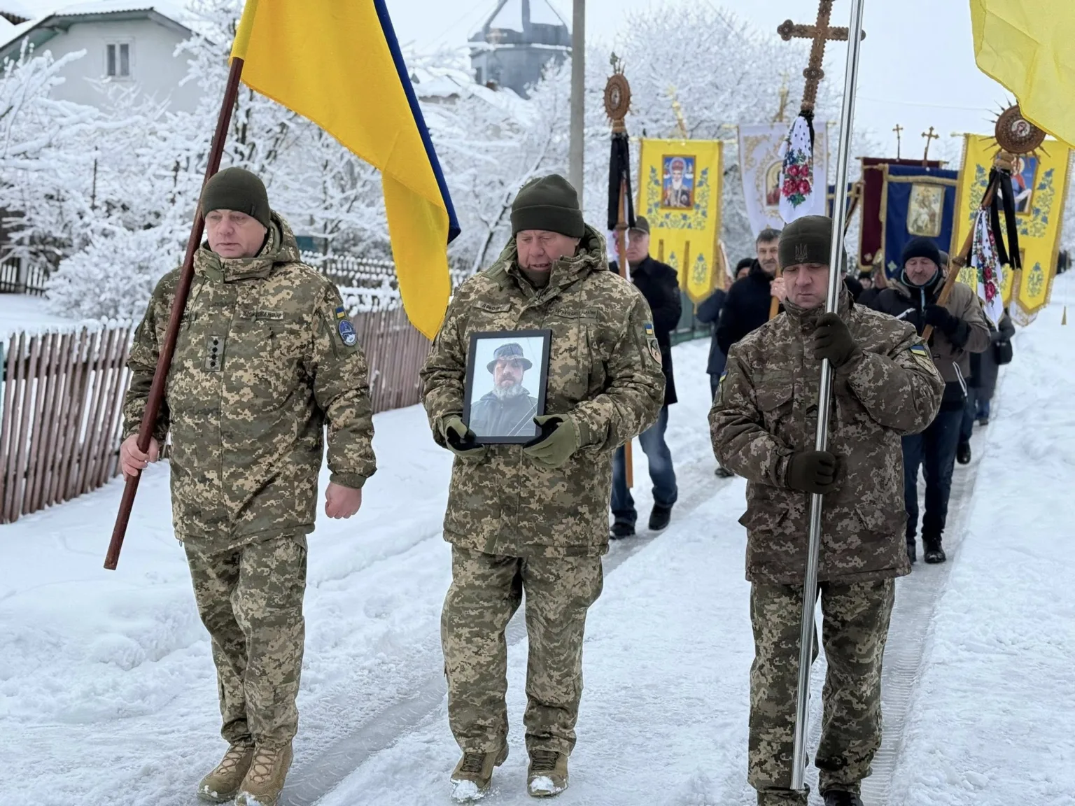 Військові несуть прапори та фотографію загиблого героя