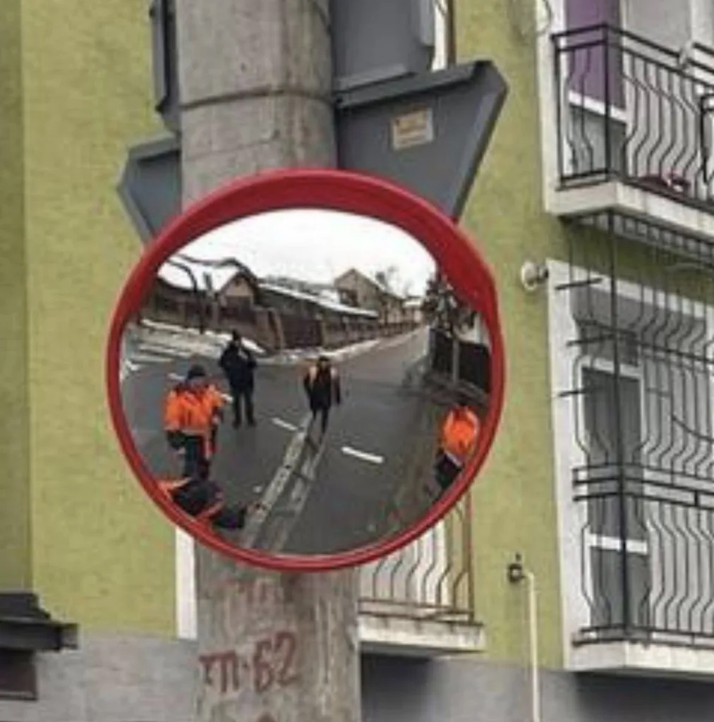 Вуличне дзеркало відображає людей на дорозі
