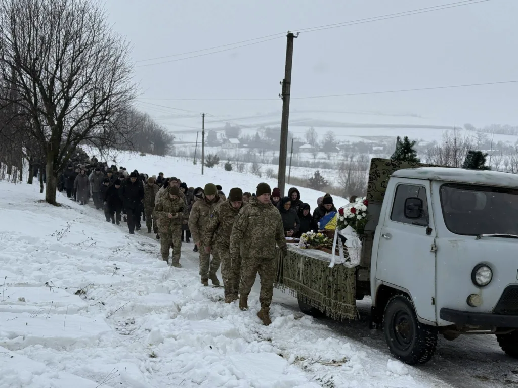 Похоронна процесія військових у засніженому селі