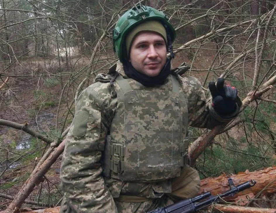 Український військовий у лісі в камуфляжі