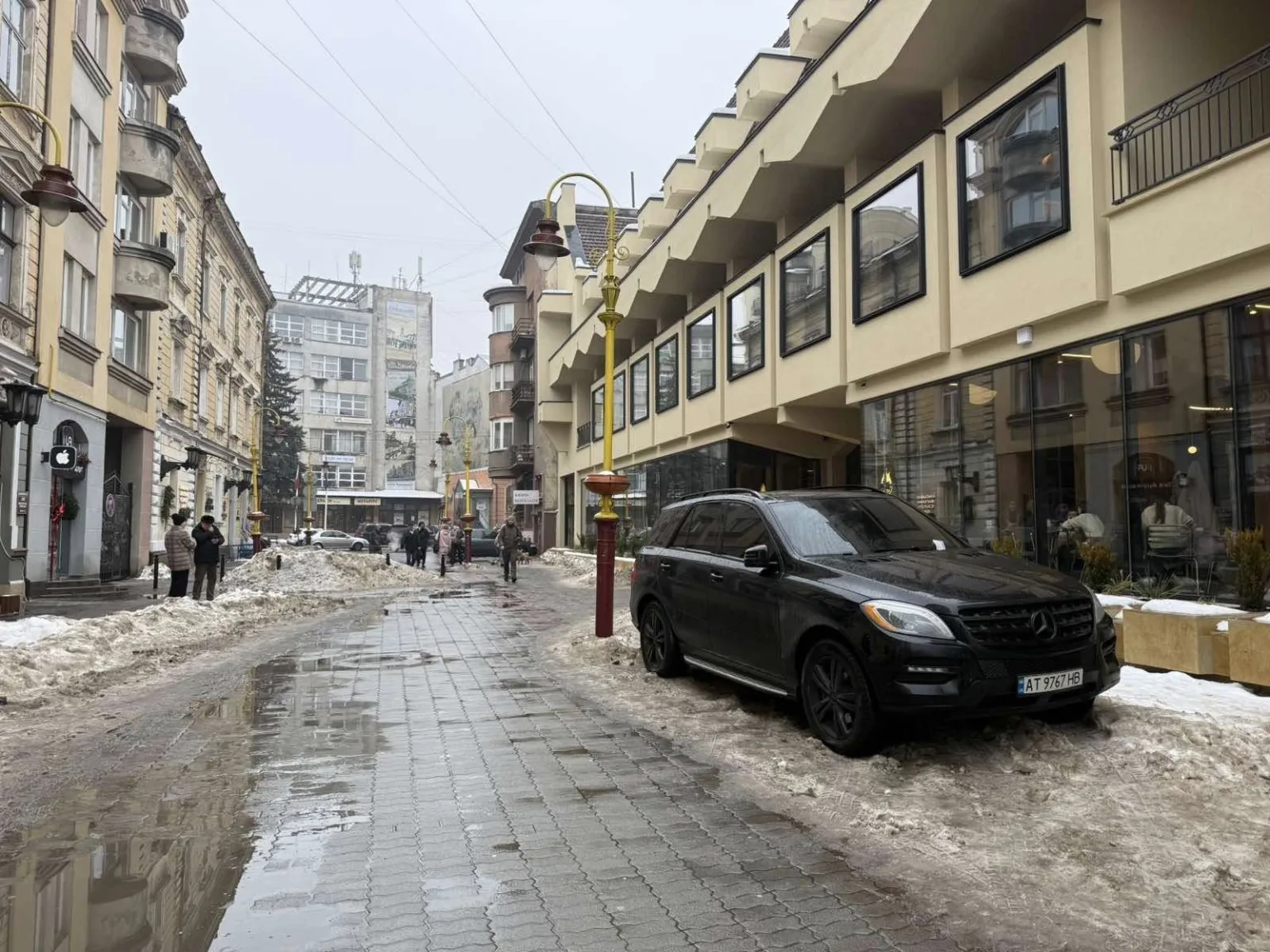 Зимова вулиця міста з припаркованим чорним автомобілем