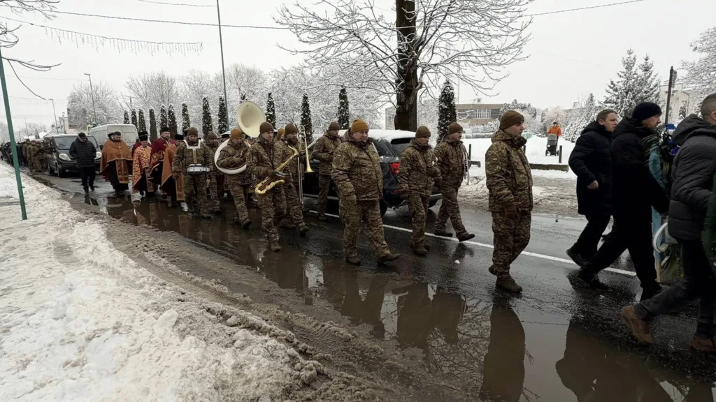 Військовий оркестр і священники йдуть зимовою вулицею