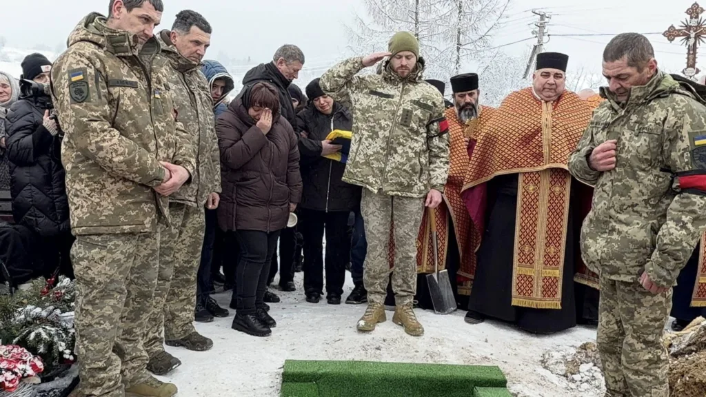 Військові та священники на зимовому похованні героя