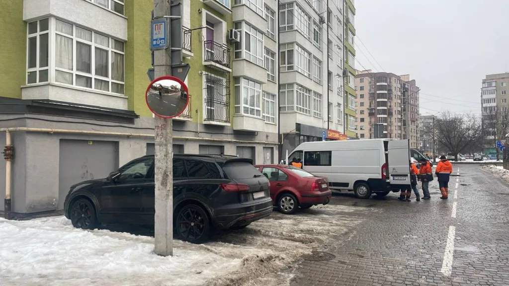 Комунальні працівники біля будинку взимку