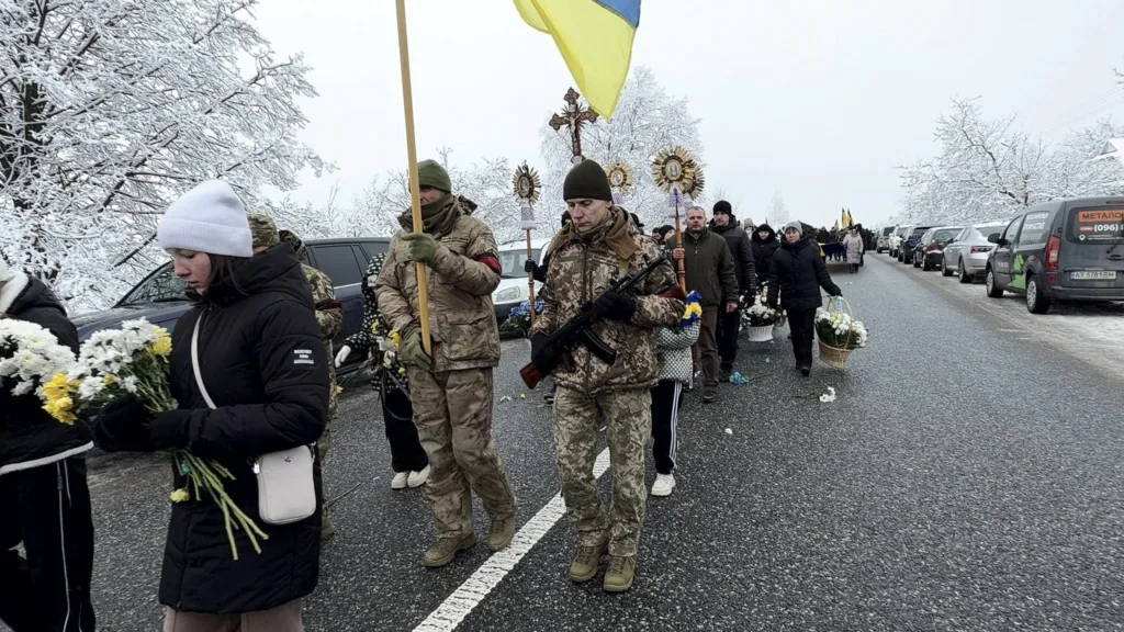 Похоронна процесія з українським прапором взимку