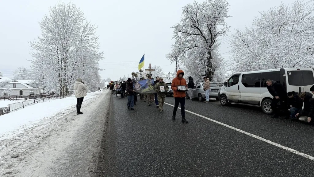 Зимова хода з українським прапором на дорозі
