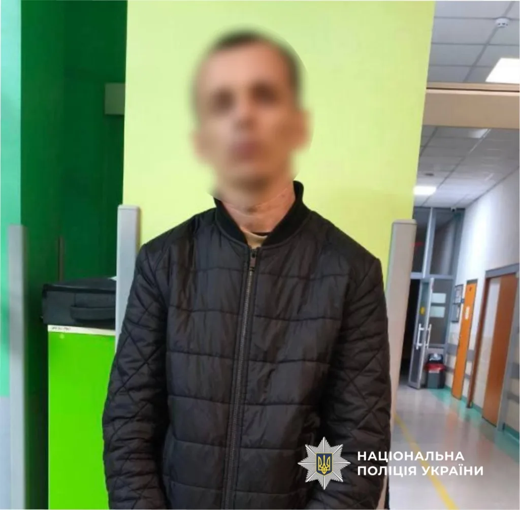 Чоловік у чорній куртці в будівлі поліції