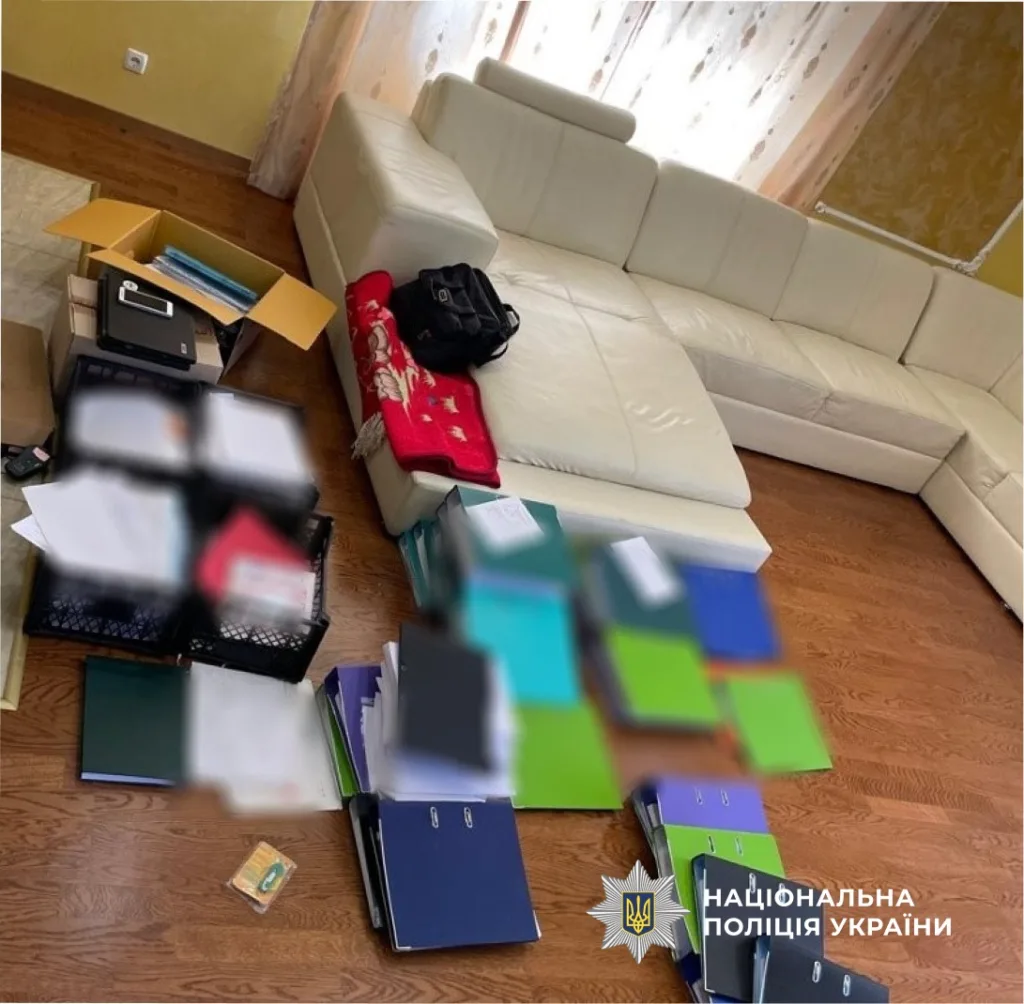 Документи та папки на підлозі біля дивану